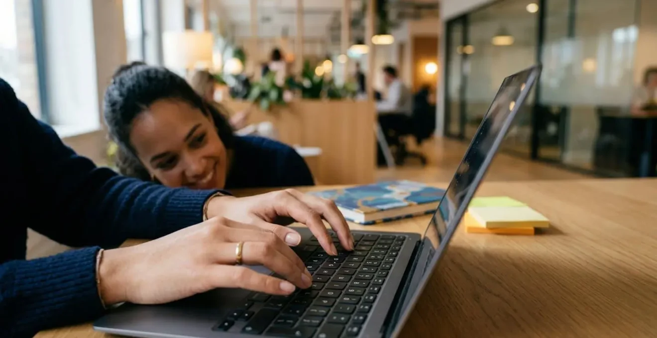 Personne rédigeant un email professionnel avec assurance dans un environnement de travail moderne